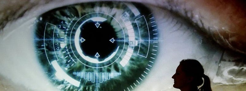 Dark silhouette of a hooded hacker at a computer